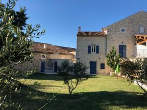 a large stone house with a yard with a tree at DOMAINE MARY'S in Barjac