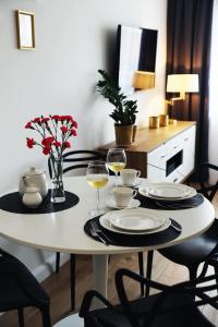 a white table with two glasses of wine at Apartamenty Silva Hel in Hel
