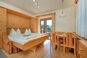 1 dormitorio con 1 cama, mesa y sillas en Hubertushof en Latschach ober dem Faakersee