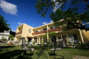 a house with two chairs and a table in the yard at Cha Villa in Zamami