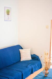 a blue couch sitting in a living room at Apartmani prvi red do mora in Pag