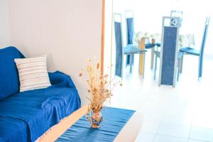 a blue couch with a vase on a table at Apartmani prvi red do mora in Pag