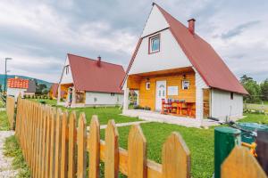 a house with a red roof behind a wooden fence at Village Borje in Žabljak