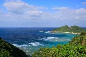 a view of the ocean with mountains in the background at Cha Villa in Zamami