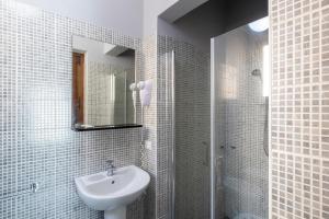 a white bathroom with a sink and a shower at Dimora La Torre Room in Favignana