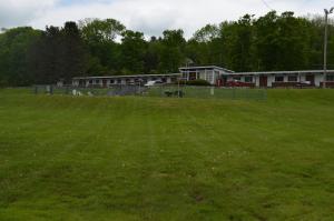 a field of green grass with buildings in the background at Paramount Motel Pocono in East Stroudsburg +13 photos