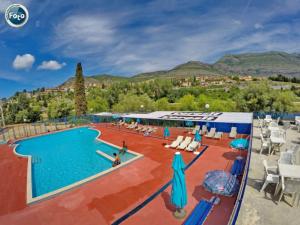 a large swimming pool with chairs and umbrellas at Apartman Ana 2 in Trebinje