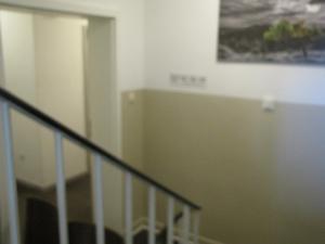 eine Treppe in einem Gebäude mit einem Gemälde an der Wand in der Unterkunft Milano Hotel in Hamburg