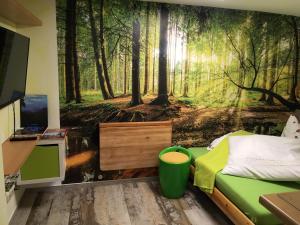 ein Schlafzimmer mit einem Wandbild eines Waldes in der Unterkunft Haus Rennsteigrose in Steinheid