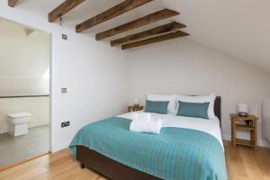 a bedroom with a large bed with blue and white sheets at ALTIDO Trendy 1-bedroom Main Door House in New Town in Edinburgh