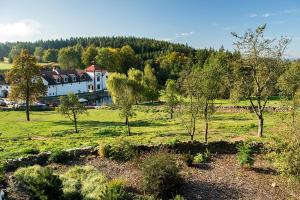 a house in the middle of a field with trees at Wellness Hotel Svachovka in Český Krumlov