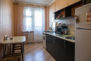 ブリャンスクにあるApartment on Romana Bryanskogoのキッチン(冷蔵庫、シンク、テーブル付)