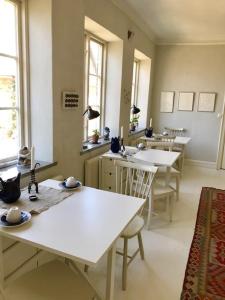 SandbyにあるLiv på Österlen Bed&Breakfastの白いテーブルと椅子、窓が備わる客室です。