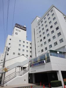 a large white building with a sign on it at Tottori City Hotel in Tottori