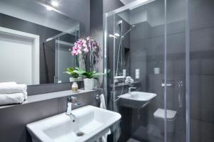 グディニャにあるSleepy3city Apartments Batorego 9 IIのバスルーム(洗面台、鏡付)