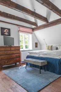 um quarto com uma cama e uma cómoda com uma televisão em meinsachsenwald forsthaus friedrichsruh em Aumühle