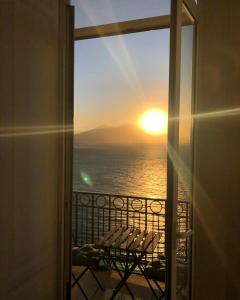 a view of a sunset from a room with a window at Lux in Naples