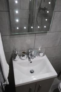 a bathroom with a white sink and a mirror at Halifax House, Studio Apartment 214 in Halifax