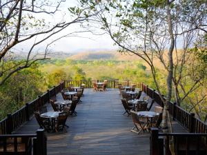 a wooden walkway with tables and chairs on a deck at The Menjangan by LifestyleRetreats in Banyuwedang