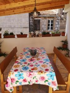 a table with a flowery table cloth on it at Apartments Milevčić in Jelsa