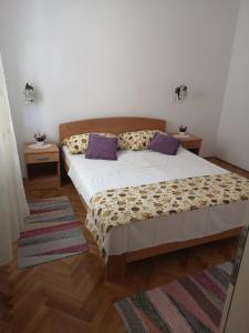 ein Schlafzimmer mit einem Bett und zwei Nachttischen in der Unterkunft Apartments Milevčić in Jelsa