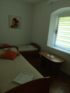 Schlafzimmer mit einem Bett, einem Tisch und einem Fenster in der Unterkunft Apartments Milevčić in Jelsa