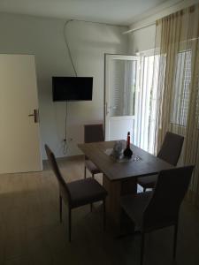 a dining room with a table and chairs and a television at Apartments Milevčić in Jelsa