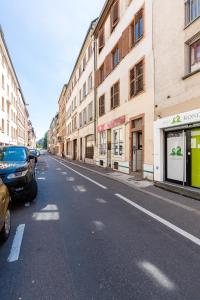 une rue urbaine vide avec des bâtiments et des voitures garés dans la rue dans l'établissement Appartement Marie, à Strasbourg