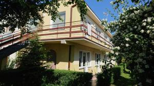 a yellow house with a balcony on top of it at Ogrodowe zacisze in Jastrzębia Góra