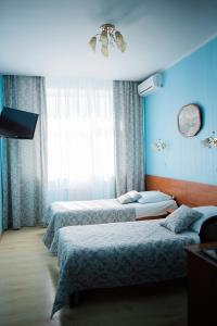 2 camas en una habitación con paredes azules en Oktyabrskaya Hotel, en Tver