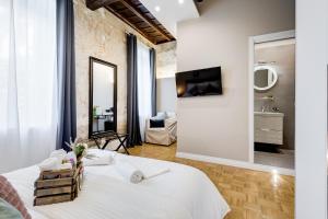 - une chambre avec un grand lit blanc et un miroir dans l'établissement Tankara Suite, à Rome