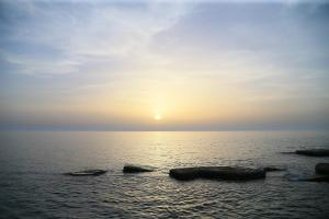a sunset over the ocean with three boats in the water at Cimer SafraMarine Beach Resort in Safra