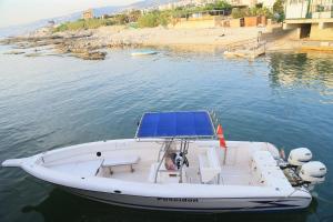 a white boat with a blue roof on the water at Cimer SafraMarine Beach Resort in Safra