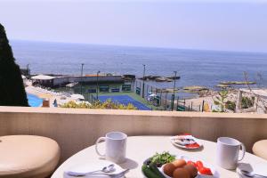 a table with a plate of food on a balcony with the ocean at Cimer SafraMarine Beach Resort in Safra