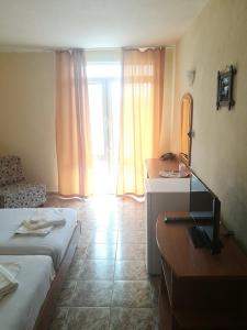um quarto com 2 camas, uma secretária e um espelho em Hotel Palace em Kranevo