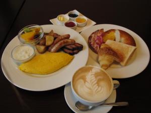 a table with two plates of breakfast foods and a cup of coffee at Kimamaya By Odin in Kutchan