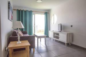 - un salon avec un canapé, une télévision et une table dans l'établissement Duplex Playa del Cura beautiful ocean view, à Mogán