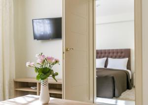 a vase of flowers on a table in a bedroom at Vila Elegancija in Palanga