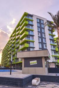 ein großes Gebäude mit einer Palme davor in der Unterkunft Green Apartment Spa n Pool Beach Resort in Mamaia Nord – Năvodari