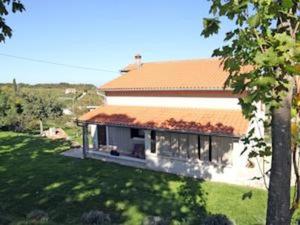 a house with an orange roof in a yard at apartman Vojskovic in Gračišće