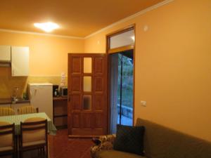 a living room with a couch and a kitchen with a door at apartman Vojskovic in Gračišće