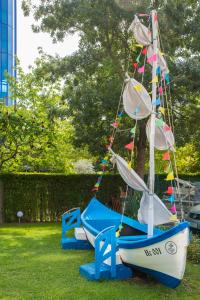 a small sail boat on display in the grass at Smartline Meridian Hotel in Sunny Beach