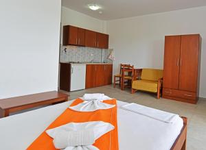 a bedroom with a bed with an orange blanket at Iraklis Hotel in Skala Rachoniou