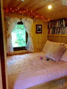 Un pat sau paturi într-o cameră la 'Morris' the shepherd's hut with woodland hot tub