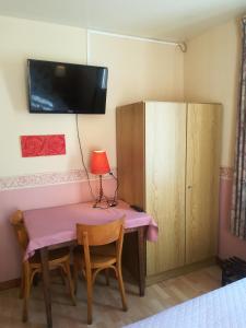 a room with a pink table and a cabinet at Hotel La Croix des Bois in Lalizolle