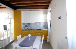 a kitchen with a table and a table and chairs at Casa Fabbro in Palazzolo dello Stella