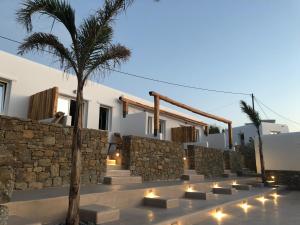 un edificio con una pared de piedra y escaleras con luces en Aelia Mykonos, en Ornos