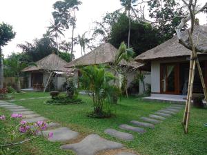 un jardin avec un chemin menant à une maison dans l'établissement Suka's House Bed & Breakfast, à Ubud