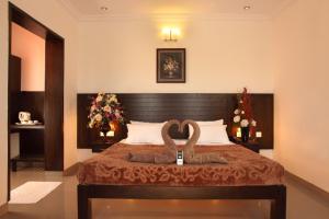 a bedroom with a bed with two towels on it at Vinay Residency in Sindhnūr +5 photos