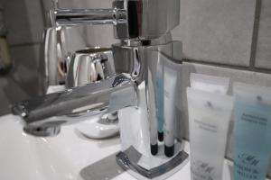 um suporte de escova de dentes de prata sentado no lavatório da casa de banho em Halifax House, Studio Apartment 215 em Halifax